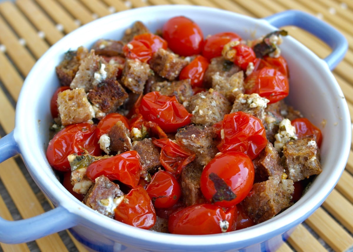 Roasted Cherry Tomatoes with Feta Cheese and Crunchy Croutons in a serving dish